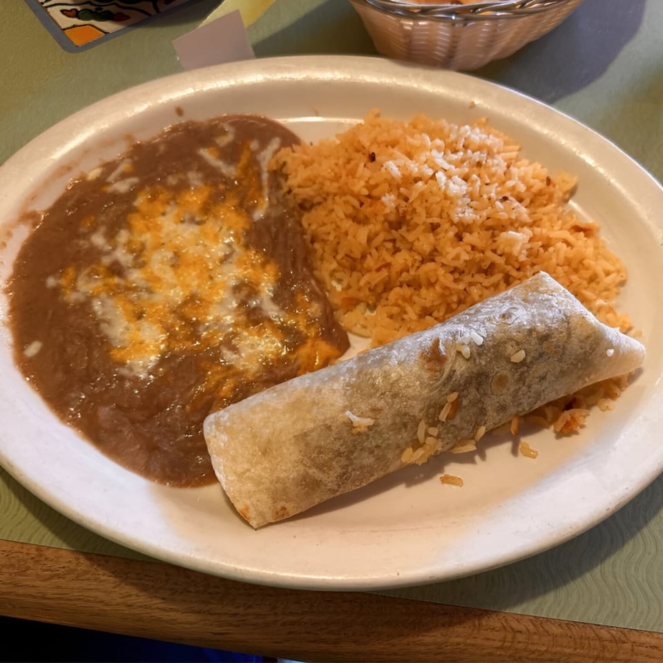 A Casa Mexico plate with a burrito, refried beans with cheese, and Mexican rice.