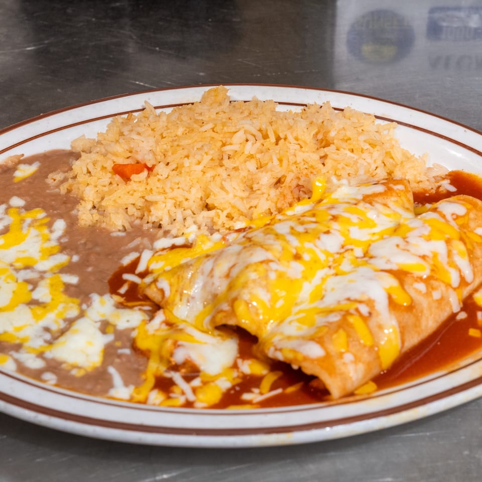 Two cheese enchiladas with red sauce, refried beans, and Mexican rice on a white plate.